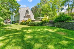 a yard with a stone fence and a house at Family Escape Luxury Retreat with Heated Pool&Firepit in Barnstable +68 photos