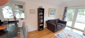 un salon avec une chaise et une table dans l'établissement Wren Cottage, à Hindhead