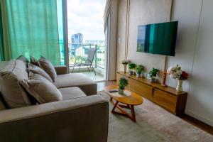 a living room with a couch and a flat screen tv at Luxury 2 Bedroom "Wake Up in the Sky" Best Views & Location in Asuncion in Asuncion