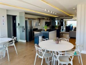 2 tafels en stoelen in een kamer met een keuken bij Scala Residenza By Holiday Stays in Fortaleza