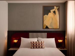 a bedroom with a bed with a painting above it at Hotel Morris Sydney, Handwritten Collection in Sydney