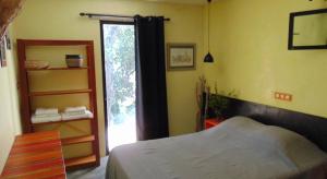 a bedroom with a bed next to a window at Les Oliviers in Patrimonio