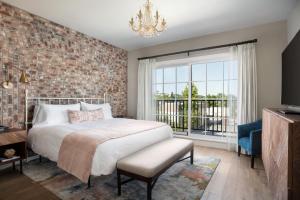a bedroom with a large bed and a brick wall at Paso Robles Inn in Paso Robles +17 photos