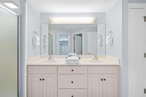 a bathroom with two sinks and a large mirror at Treasure Island 707 in Panama City Beach