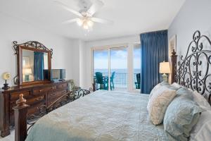 a bedroom with a bed with a dresser and a mirror at Treasure Island 707 in Panama City Beach
