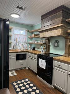 a kitchen with white cabinets and a black stove top oven at Alice by Ravens Keep in Jackson +16 photos
