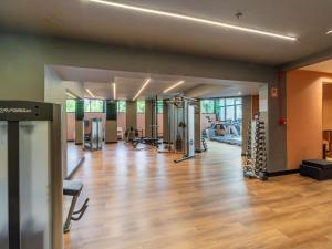 a gym with exercise equipment and a wooden floor at Manhattan Porto Alegre by Mercure - 5 minutos do Hospital Moinhos de Vento in Porto Alegre