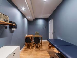 a room with blue walls and a table and chairs at Manhattan Porto Alegre by Mercure - 5 minutos do Hospital Moinhos de Vento in Porto Alegre
