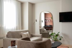a living room with two chairs and a mirror at Maison Saint-Vincent By Maisons & co in Montréal