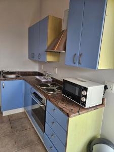 Una cocina con armarios azules y un microondas en la encimera. en Fair View, en Somerset West