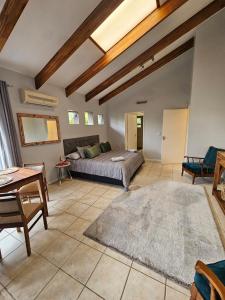 Una gran sala de estar con una cama y una mesa. en Fair View, en Somerset West