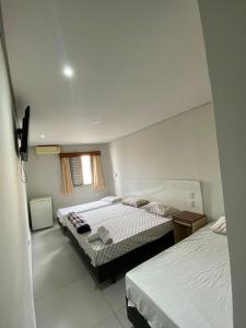 a bedroom with two beds and a window at Pousada Recanto do Brás in Sao Paulo