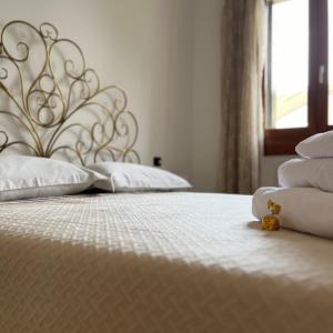 une chambre avec deux lits avec draps blancs et oreillers dans l'établissement Dimore Al Borgo, à Montagnana