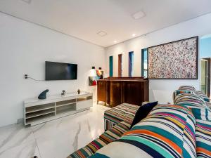 a living room with a couch and a tv at Casa Vista Mar com piscina na Orla De Atalaia in Santa Maria