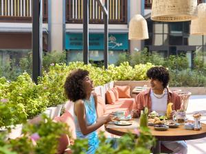 a man and woman sitting at a table in a garden at ibis Styles Dubai Deira in Dubai