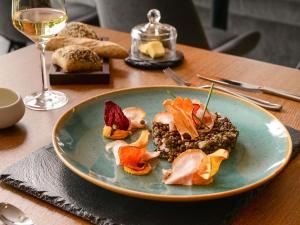 a plate of food on a table with a glass of wine at Mercure Geneva Airport in Geneva