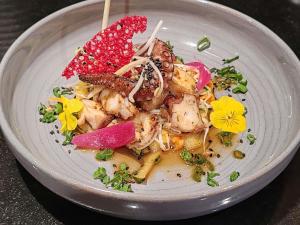 a plate of food with meat and flowers on it at Mercure Geneva Airport in Geneva