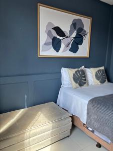 a bedroom with two beds and a painting on the wall at Recanto Central Premium in Vitória da Conquista