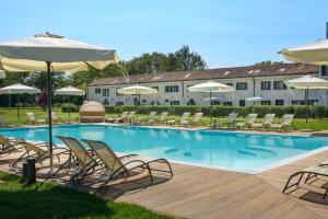 a swimming pool with lounge chairs and umbrellas at Hotel Villa Barbarich Venice Mestre in Mestre