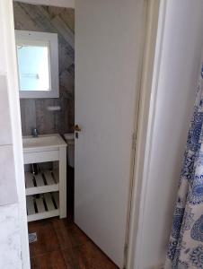 a bathroom with a white door and a sink at Alquituc Escobar in Belén de Escobar