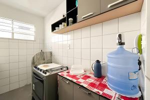 a kitchen with a large water jug on the counter at Apto com AR, 3/4 em condomínio com piscina e lazer in Aracaju