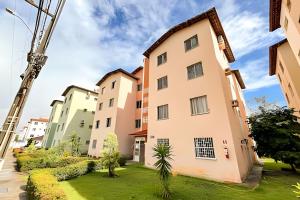 a row of apartment buildings with a green yard at Apto com AR, 3/4 em condomínio com piscina e lazer in Aracaju