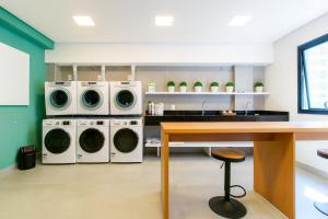 a laundry room with two washing machines and a table at 1306 - Luxuoso Studio BF - CWB Central - Com Garagem in Curitiba +11 photos
