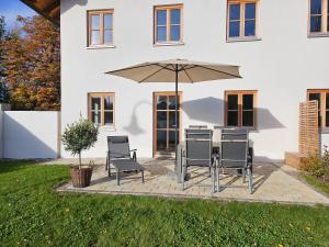 a patio with a table and chairs and an umbrella at Ferienwohnung Ott in Halblech
