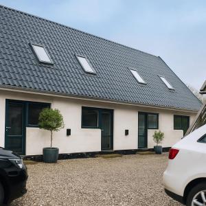 a white house with a black roof at Aarhus Stay Apartments in Hasselager +11 photos