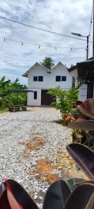 a white house with a garage in front of it at Homestay A&R Home in Yan