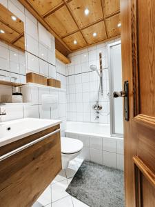 um banheiro com banheira, vaso sanitário e pia em ALPINE Appartement 407 Schladming by globboard em Schladming