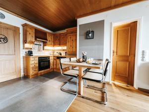 uma cozinha com armários de madeira e uma mesa e cadeiras de madeira em ALPINE Appartement 407 Schladming by globboard em Schladming