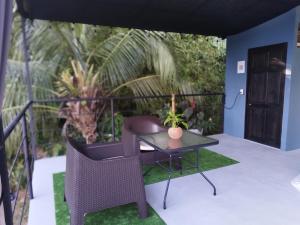a patio with a table and chairs on a balcony at Osaglamping in Palmar Norte +8 photos