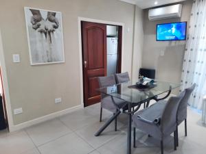 a dining room with a glass table and chairs at Dunas I, 3 in Pinamar