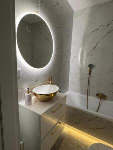 a bathroom with a bowl sink and a mirror at Nowe luksusowe Apartamenty MANUFAKTURA-Prywatny na wyłączność-Wanna-Zamykany ogrodzony Parking, Blok,Niskie pietro-cisza i spokój in Łódź