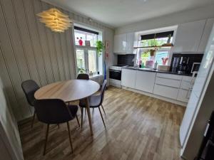 a kitchen with a table and chairs in a room at Leilighet sentralt i Tromsdalen in Trondalen