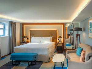 une chambre d'hôtel avec un grand lit et une chaise dans l'établissement Queen Elizabeth 2 Hotel, à Dubaï 109 autres photos