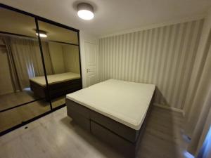 a small bedroom with a bed and a mirror at Leilighet sentralt i Tromsdalen in Trondalen