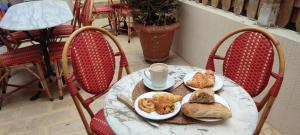 a table with a plate of bread and a cup of coffee at PARIS AUTHENTIC HOUSE open space studio Métro 14 Hôpital Bicêtre, RER B Gentilly in Gentilly