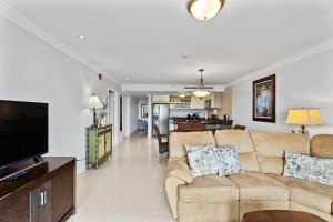a living room with a couch and a flat screen tv at Beachfront - Best View 2BR condo - E422-2 in Palm-Eagle Beach