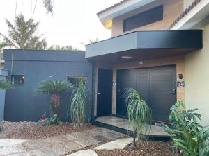 a house with a blue door and some plants at Studio aconchegante - Próx Thermas - Carrara de Carrara in Andradina