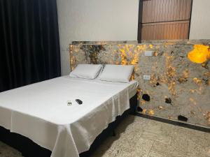 a bed with two pillows on it in a room at Belíssimo Estudio Stella Maris in Andradina