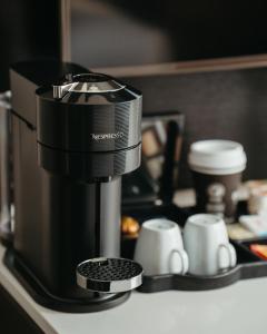 a coffee maker sitting on a counter with coffee cups at Delta Hotels by Marriott Sherbrooke Conference Centre in Sherbrooke +25 photos