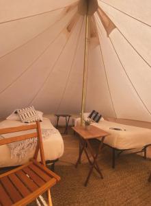 Tienda con 2 camas, mesa y silla en Starlight Olympic Glamping, en Port Angeles