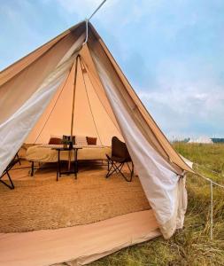 Tienda de campaña con mesa y silla en un campo en Starlight Olympic Glamping, en Port Angeles