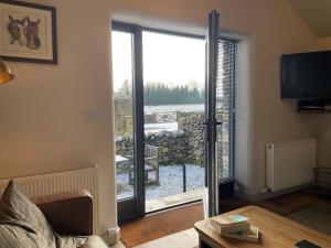 a living room with a sliding glass door to a patio at 1 Bed in Ullswater 94068 in Watermillock