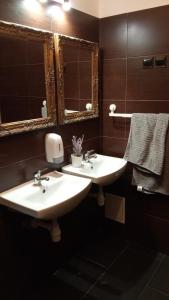 a bathroom with two sinks and two mirrors at Rembrandt Hostel in Kraków