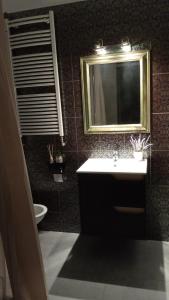 a bathroom with a sink and a mirror and a toilet at Rembrandt Hostel in Kraków