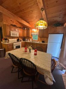a kitchen with a table with chairs and a refrigerator at Augur Lake Cabin Escape in Au Sable Forks