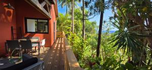 a porch of a house with trees and plants at Lilie Location Sapotis in Saint-Joseph